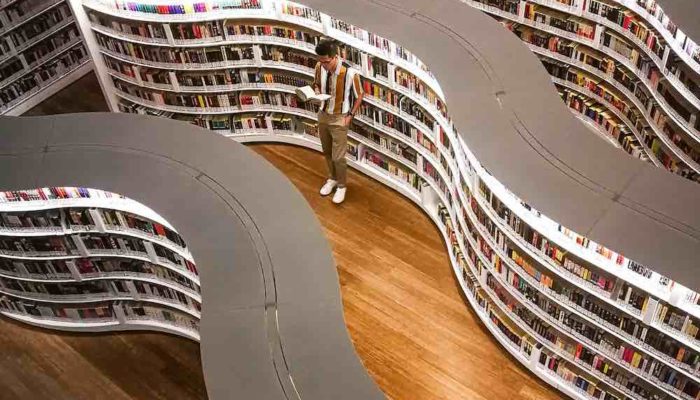 man reading book in french library