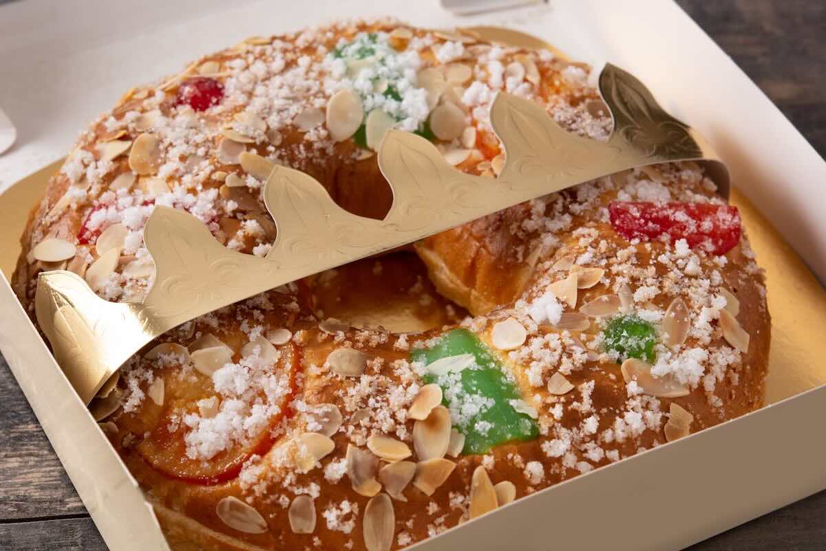 Golden, braided brioche galette with candied fruits and sugar topping, served on a festive plate
