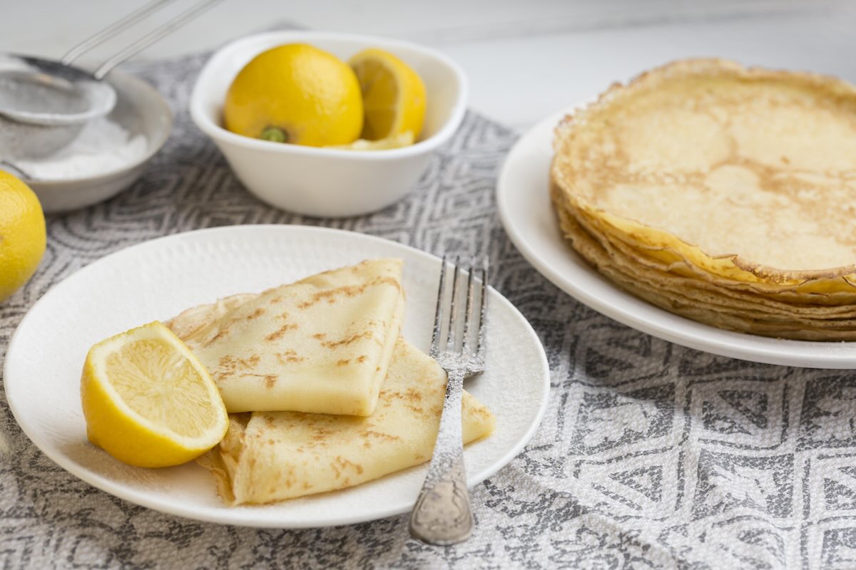 La Chandeleur in France with golden crêpes, flipping crêpes for good luck, and festive French traditions
