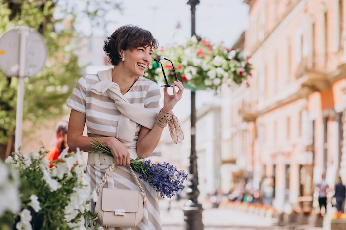 Young woman with flowers walking in town Femme se promenant dans Paris pendant une immersion en français